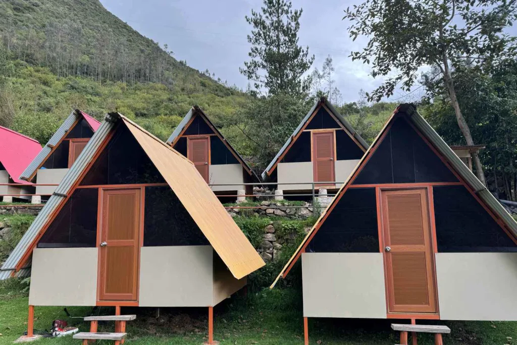 Salkantay Lodge Collpapampa, caracterizado por sus cabañas de estilo A-frame con estructuras beige y techos metálicos