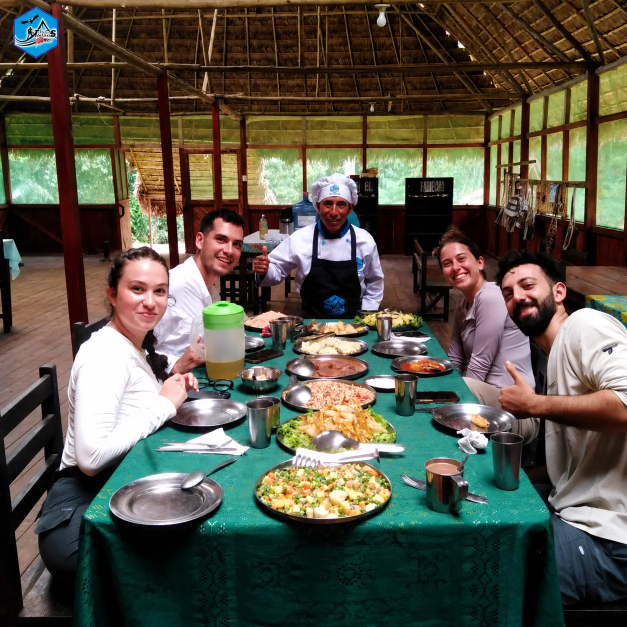 grupo de personas cenando en un restaurante tipo cabaña con techo de paja en un entorno natural