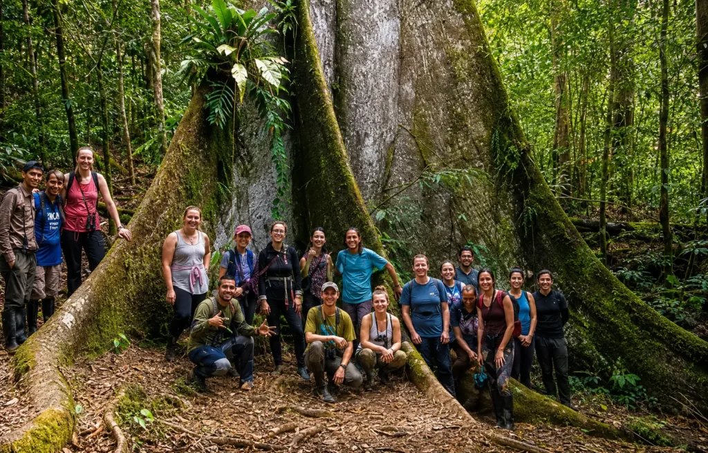 grupo de turistas posando junto a un imponente árbol Ceiba pentandra en la selva amazónica
