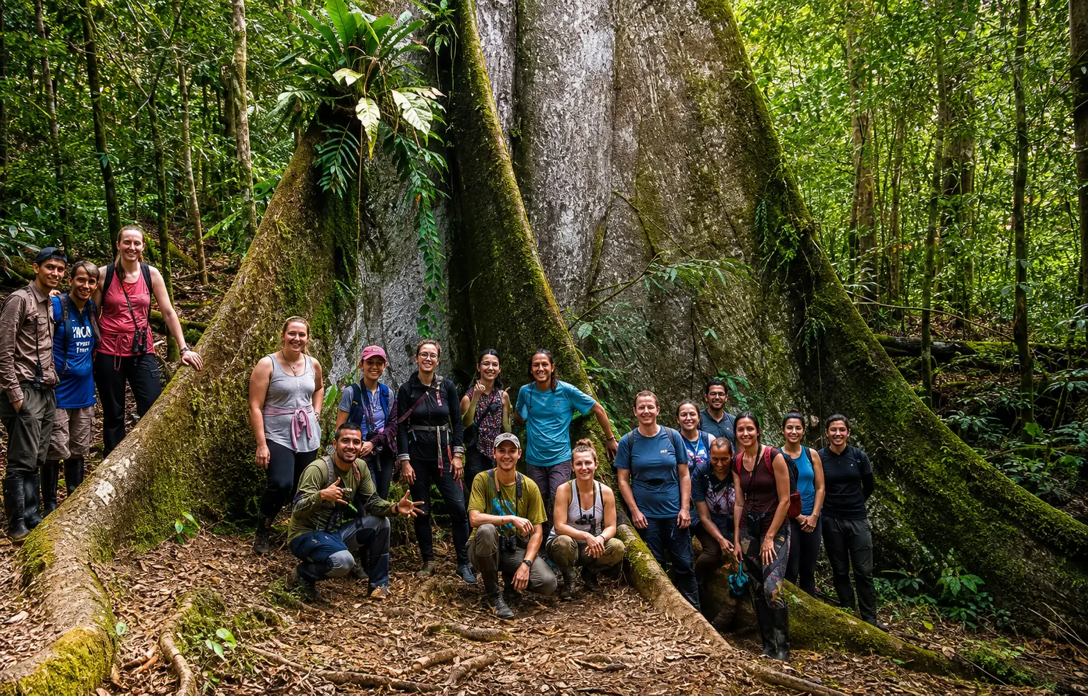 grupo de turistas posando junto a un imponente árbol Ceiba pentandra en la selva amazónica